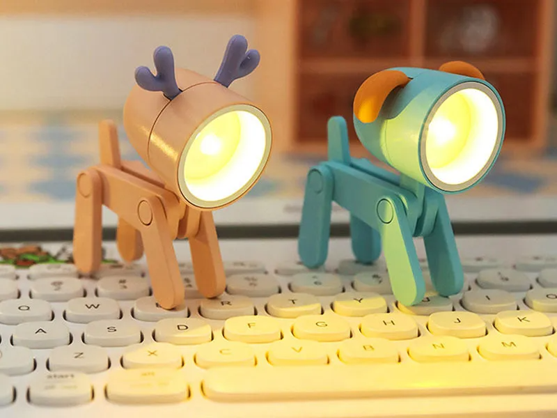 Two cartoon-style animal lamps, one deer and one dog, on a keyboard.