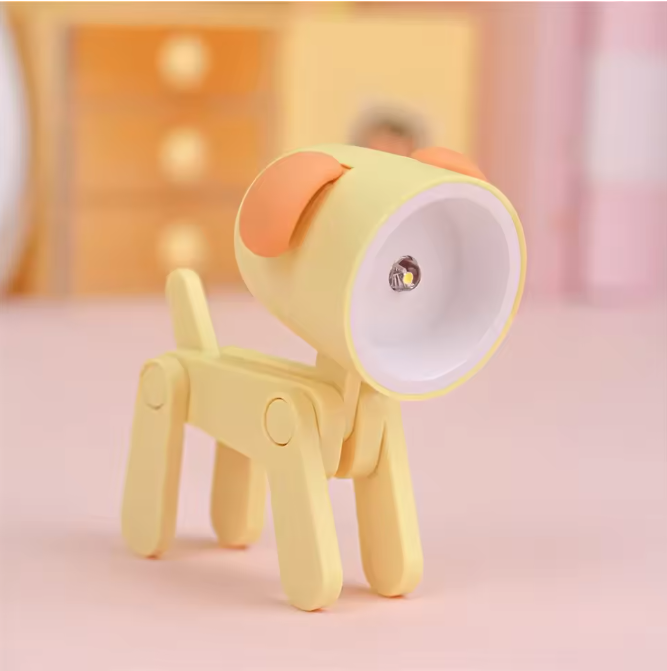 Yellow dog-shaped night light on a pink surface with a blurred background
