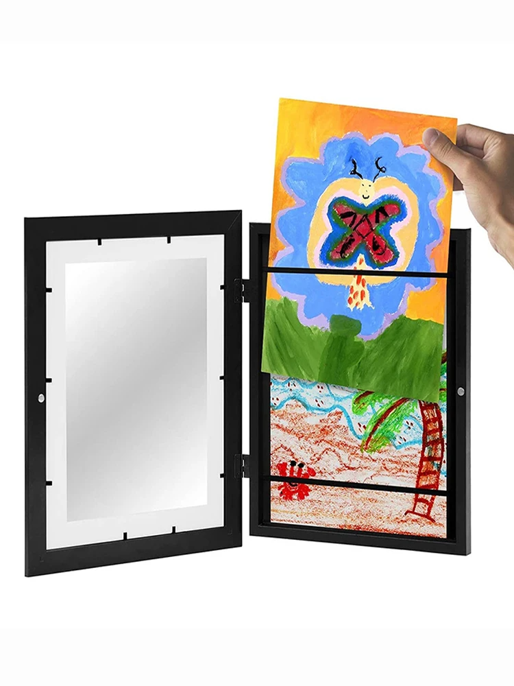 Hand holding a colorful drawing of a butterfly inside a black frame with a white interior.
